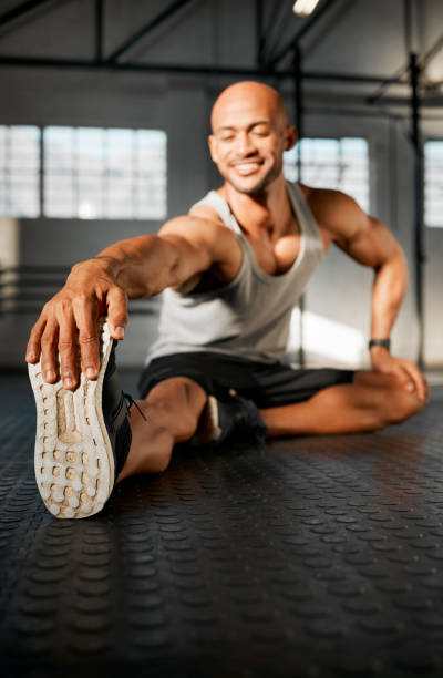 istock Shot of a young man stretching his legs before a workout 1369509393
