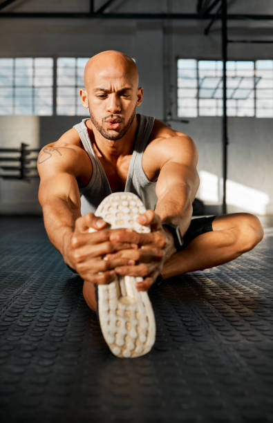 istock Shot of a young man stretching his legs before a workout 1369509394
