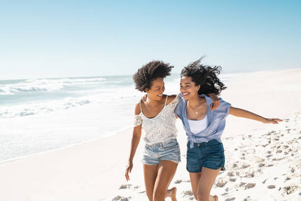 amigas felices corriendo en la playa de verano con espacio de copia - couple young women casual excitement fotografías e imágenes de stock