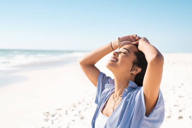 istock Latin woman enjoy the sun while relaxing at beach 1369509533