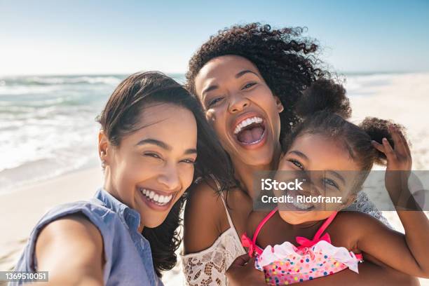 海辺で自分撮りをする子供と幸せな女性の友人 - 家族のストックフォトや画像を多数ご用意 - 家族, バケーション, 海岸