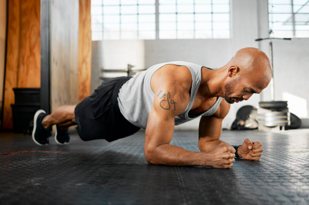 istock Shot of a young man completing a plank session 1369510862