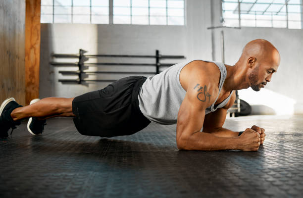 istock Shot of a young man completing a plank session 1369510867