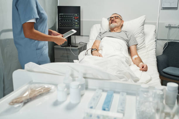 istock Unrecognizable medical worker holding digital tablet talking to mature man checking his health state in hospital room 1369510978