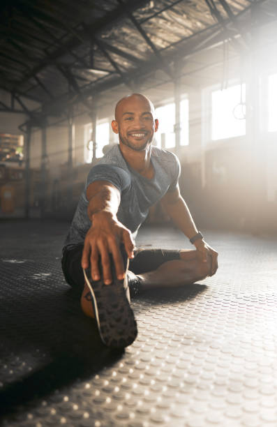 istock Shot of a young man stretching his legs before a workout 1369512001