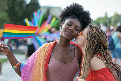 Lesbian couple kissing and hugging at the pride parade