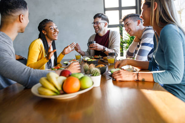 istock Young cheerful friends talking during lunch at home. 1369512451