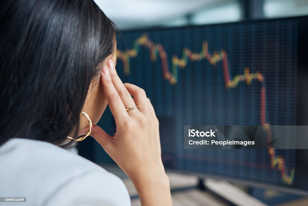Shot of an unrecognisable businesswoman sitting in her office at night and feeling stressed while using her computer There's absolutely nothing I can do Stock Market and Exchange Stock Photo