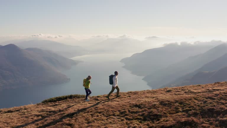 Aerial shot, couple walking on mountain trail on a hike