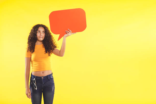 Teenager holding speech bubble on yellow background