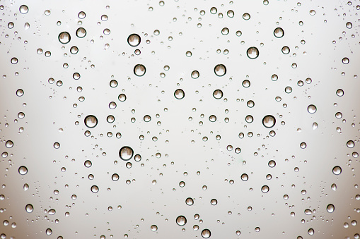 Close-up of water drops on silver surface, wet background