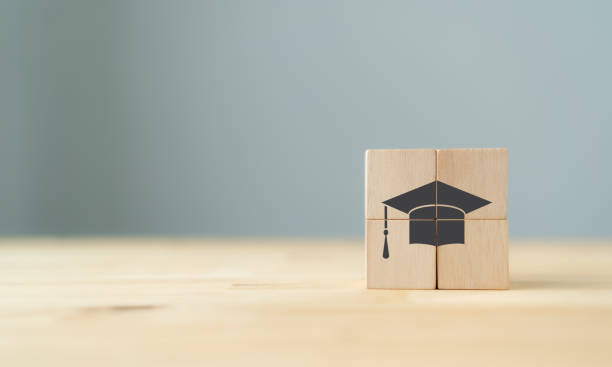 istock Graduation from university, education, diploma concept. Happiness cheerful feeling, Commencement, Graduation day. The wooden cubes with graduation cap on beautiful grey background and copy space. 1369519173