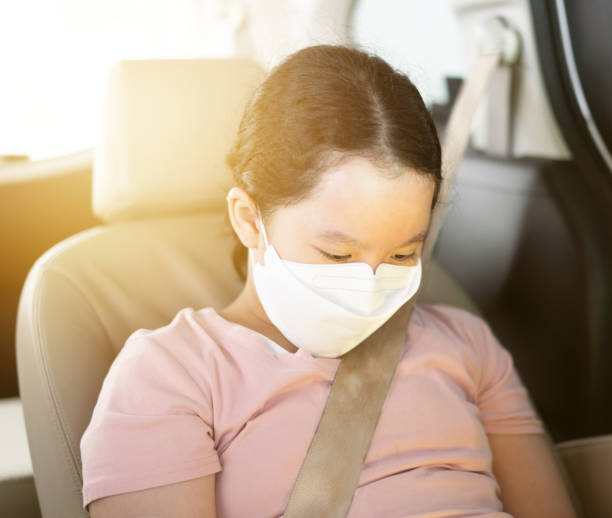 istock young girl sit in car with protect mask in covid quarantine 1369522349