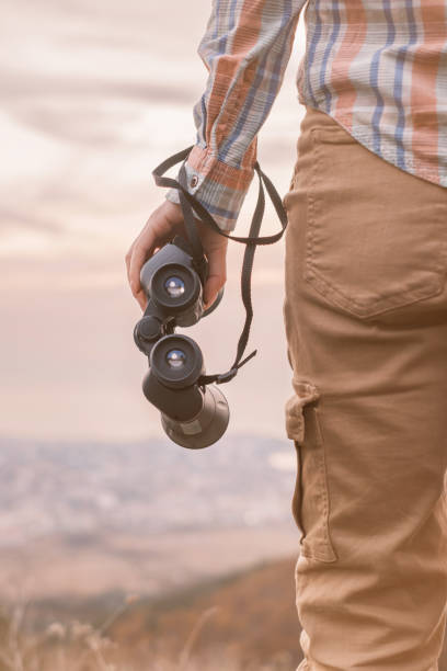 istock Traveler holding binoculars in a hand. 1369522384