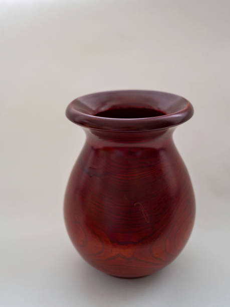 istock Round mahogany-colored wooden vase on white background 1369522394