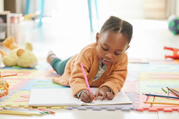 foto de una niña relajándose y dibujando - preschool fotografías e imágenes de stock