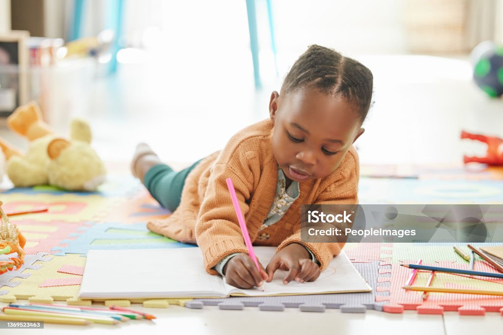 Shot of a little girl relaxing and drawing Working on her magnum opus Preschool Stock Photo