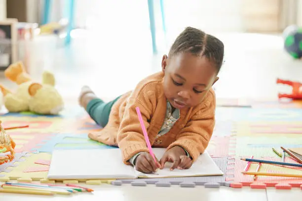 Photo of Shot of a little girl relaxing and drawing