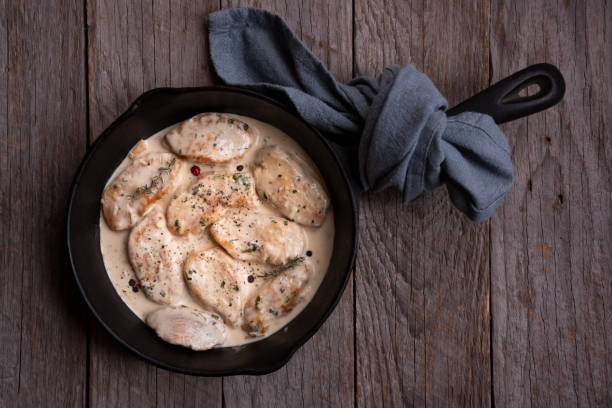 istock Cooked chicken breast with creamy sauce in frying pan 1369524110