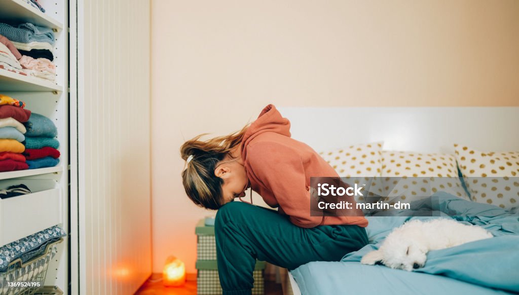 Woman with stomach pain staying home Young woman with painful menstruation resting in bed Stomachache Stock Photo