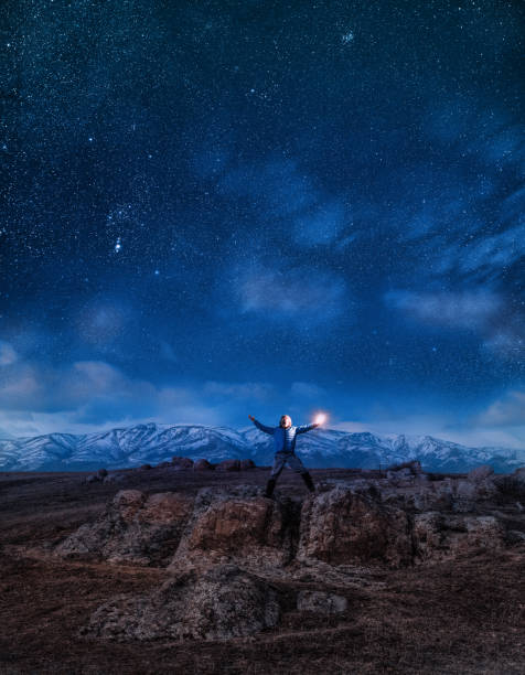 istock Man at night with arms outstretched in nature. 1369525379