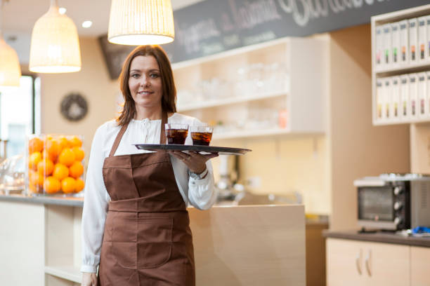 istock Female barista serving drinks 1369525801