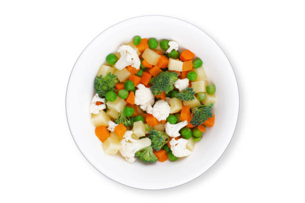 fresh mixed frozen vegetables on round plate isolated on white background stock photo