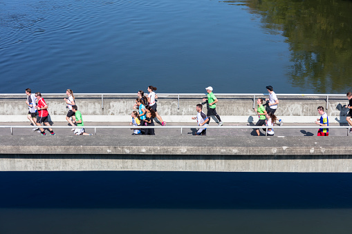 Baden Wurtemberg, Germany - Oktober 19, 2018: Amateur runners running over the footbridge over the river Danube, Germany.