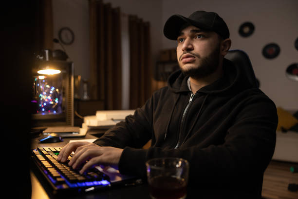 istock A professional programmer sits late at night at a computer with a light on, fills out documents over a cup of coffee, writes a software script, checks databases, remote infromatics work 1369529789