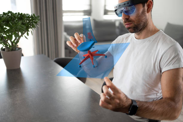 Augmented reality-designing A male furniture designer wears virtual reality glasses and works on a 3D model hologram visualization of an office chair that he is creating. augmented reality stock pictures, royalty-free photos & images