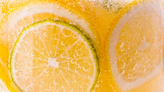 Close-up of carbonated water with slices of lemon and lime.