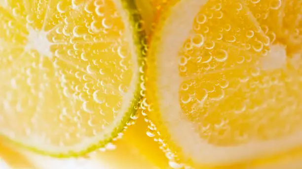 Close-up of carbonated water with slices of lemon and lime.