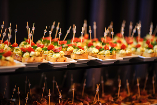 Wedding fourchette table decorated with sandwiches with mozzarella tomatoes prosciutto