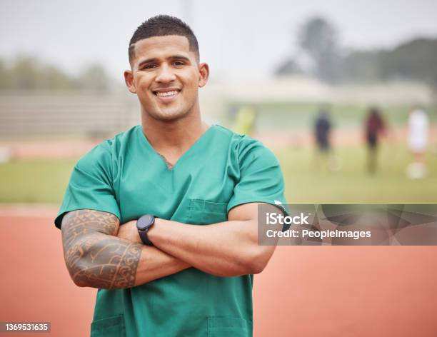 Cropped Portrait Of A Handsome Young Male Paramedic Standing With His Arms Folded On A Track Outside Stock Photo - Download Image Now