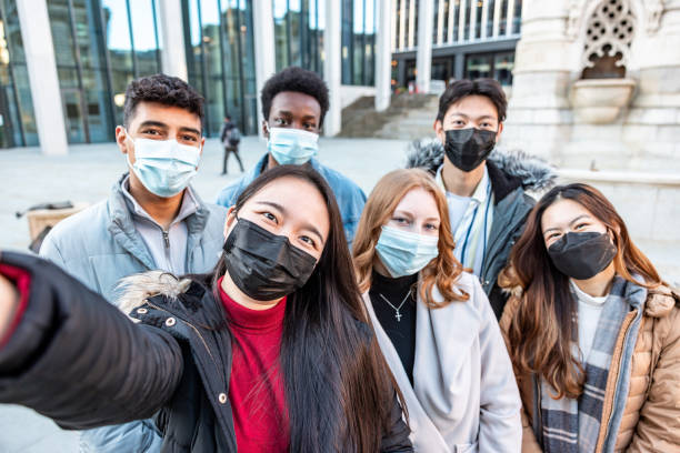 istock Multiracial friends taking a selfie together wearing face mask 1369532787