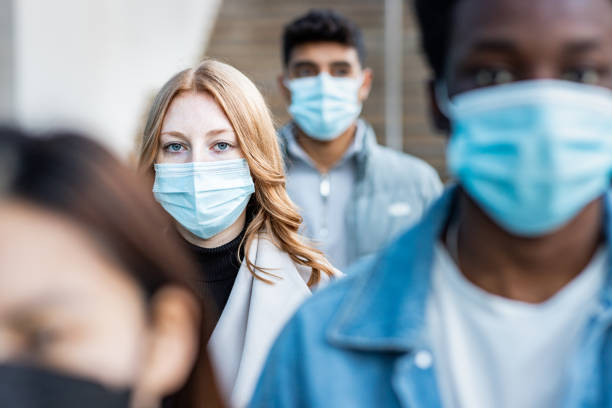 multiracial people in the city wearing face mask - masker stockfoto's en -beelden