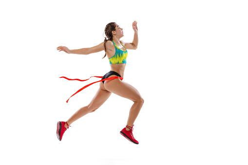 First place. Studio shot of professional female runner, athlete in summer sports uniform training isolated on white background. Muscular, sportive woman. Concept of action, motion, youth, healthy lifestyle.