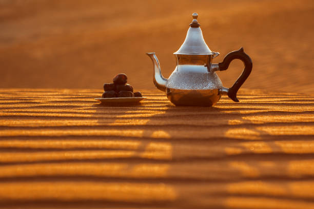 istock Arabian teapot and dates in the desert at a beautiful sunset symbolizing Ramadan 1369533604