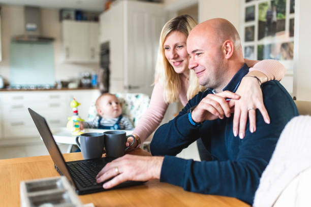 foto en casa con una familia joven que trabaja desde casa y tiene un bebé recién nacido - couple healthy lifestyle real people characters fotografías e imágenes de stock