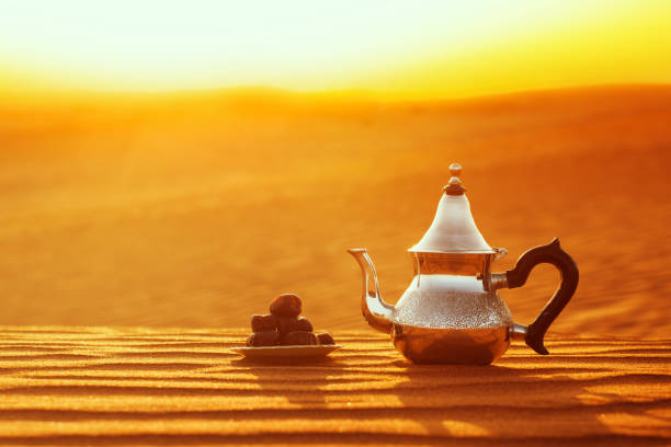 istock Arabian teapot and dates in the desert at a beautiful sunset symbolizing Ramadan 1369534587