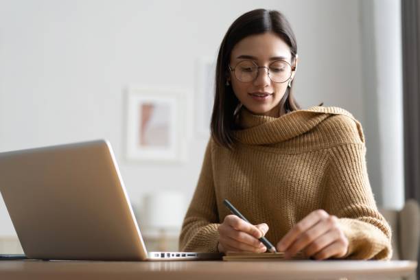 istock Smiling woman with laptop in home office. 1369535065