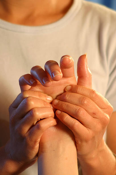 Closeup of woman masseuse massaging man's hand A massage therapist working on a reflex point in the palm of the hand. hand massage photos stock pictures, royalty-free photos & images