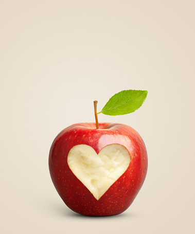 Red heart on ripe red apples, healthy food idea.