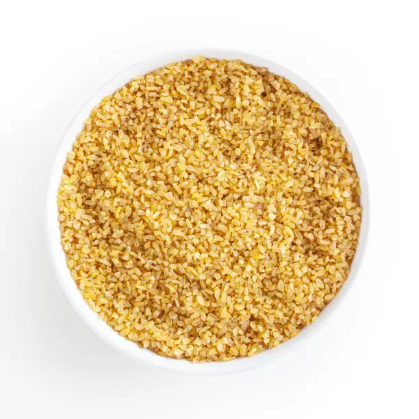 Dried bulgur in white bowl isolated on white background with clipping path