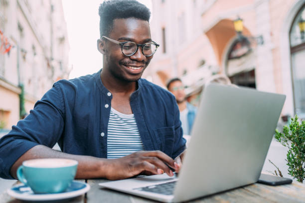 istock Young man sitting in coffee shop and using laptop. 1369536871