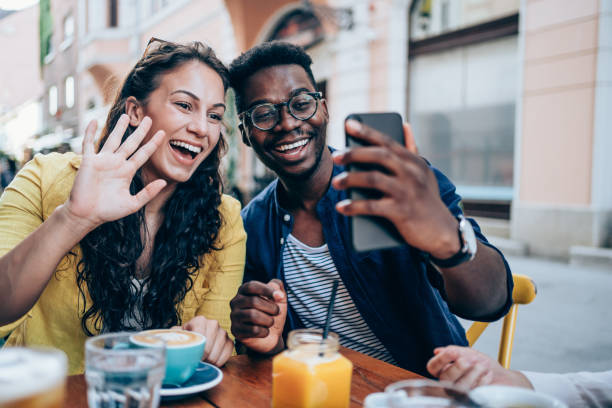 istock Couple having video call on smartphone in cafe. 1369536886