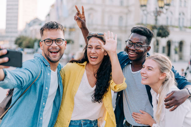 istock Friends taking selfie while walking on city street. 1369536907