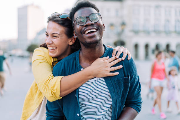 coppia felice che si abbraccia all'aperto. - couple young adult african descent multi ethnic group foto e immagini stock