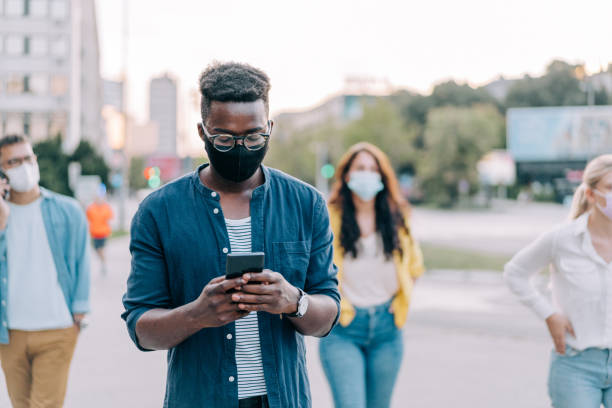 istock People with protective masks walking outdoors in the city. 1369536923