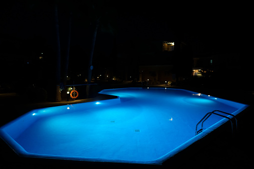 Modern backyard water pool at night.